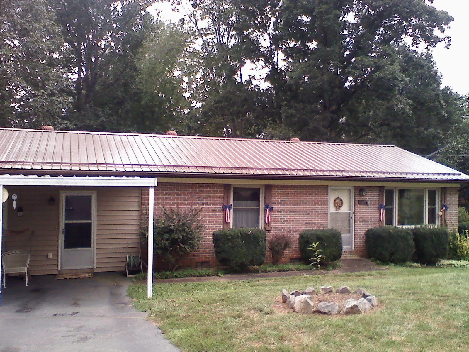Bronze metal roof and carport on a brick ranch home — Roof Repair work by our crew in Farley